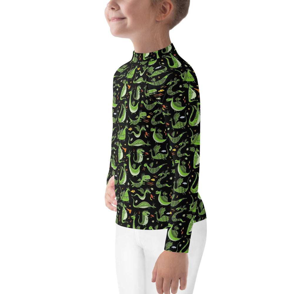 Little girl in Rash Guard black color with funny Green Dragons designer print. Left