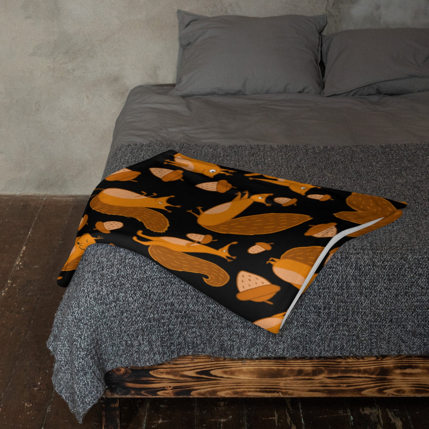 Throw blanket black color with funny orange squirrels and nuts on bed
