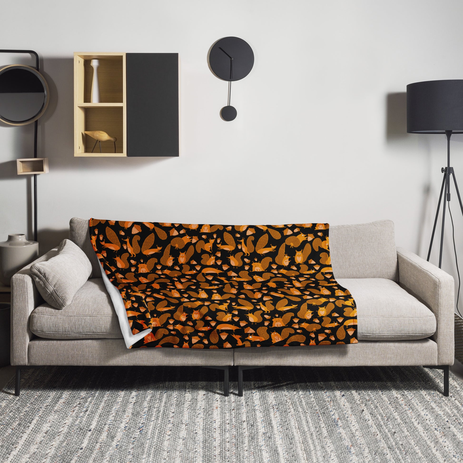 Design interior with Throw blanket black color with funny orange squirrels and nuts on sofa