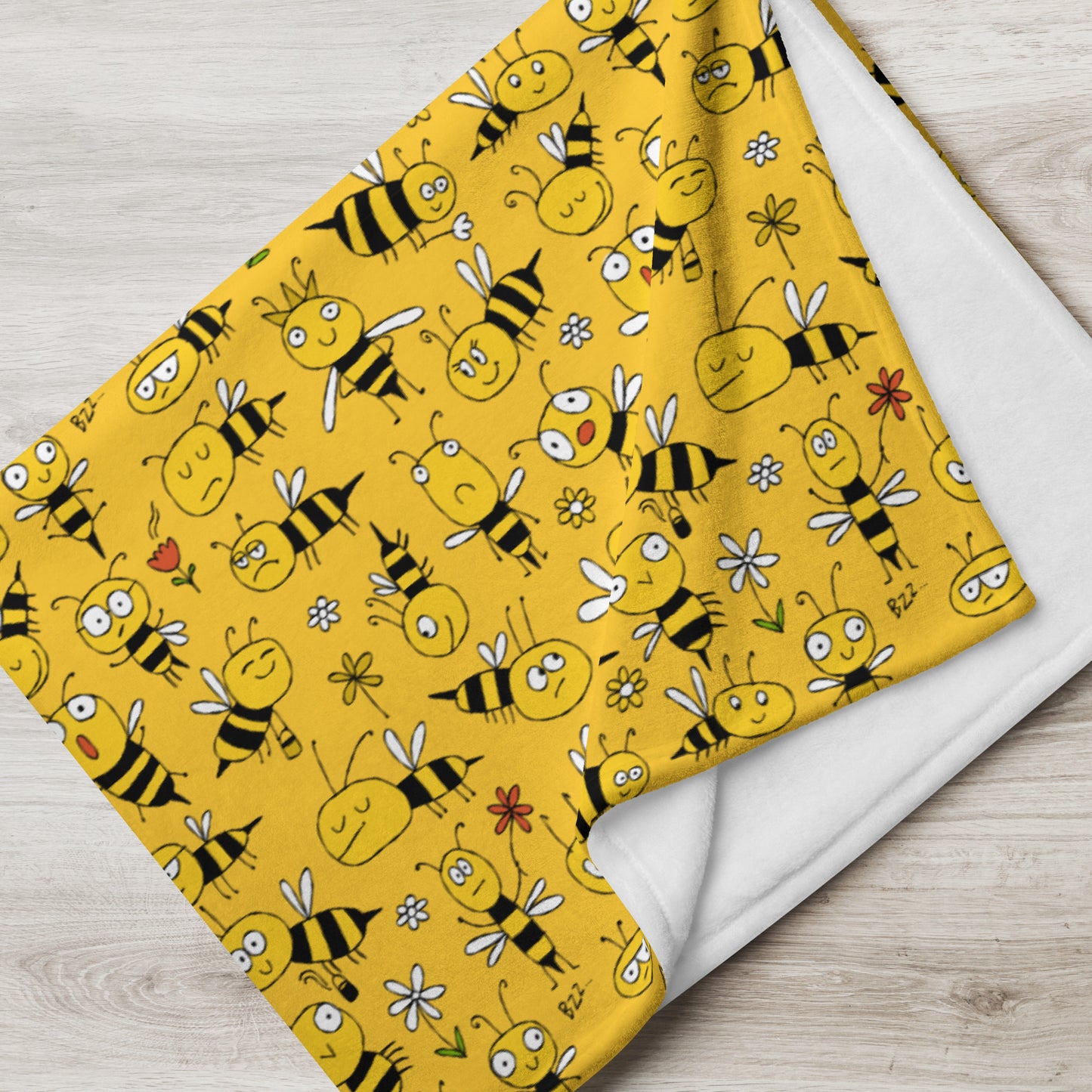 Yellow fabric with bee pattern on a wooden surface